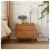 cherry-wood-nightstand-lifestyle-scene-reading-in-bed Cherry wood two-drawer nightstand beside the bed in a lifestyle reading scene