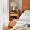 Cherry wood sliding door nightstand on casters front view angle