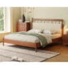 Cherry platform bed with upholstered carved headboard in a warm bedroom setting