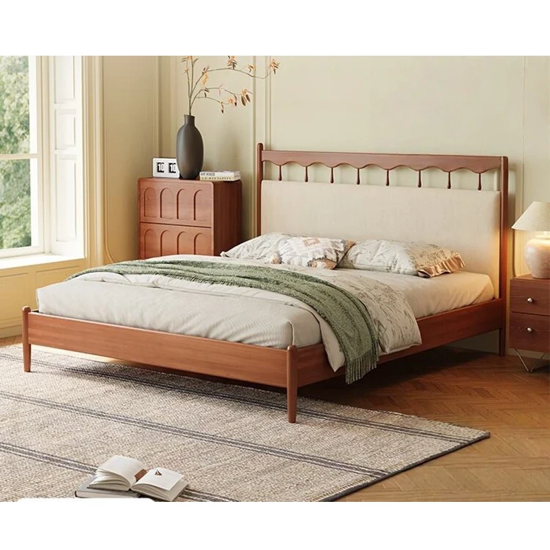Cherry platform bed with upholstered carved headboard in a warm bedroom setting