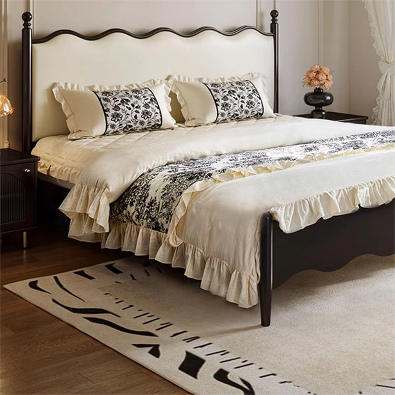 Cream upholstered bed frame with black wood posts and wavy headboard front view