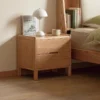 Natural oak 2 drawer nightstand in a cozy bedroom lifestyle scene