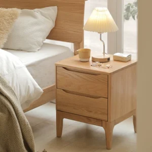 Natural oak two-drawer nightstand beside a bed in a soft daylight bedroom scene