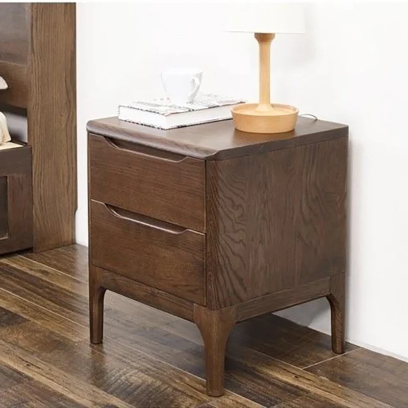 Oak two-drawer nightstand lifestyle scene with a bedside vase and lamp