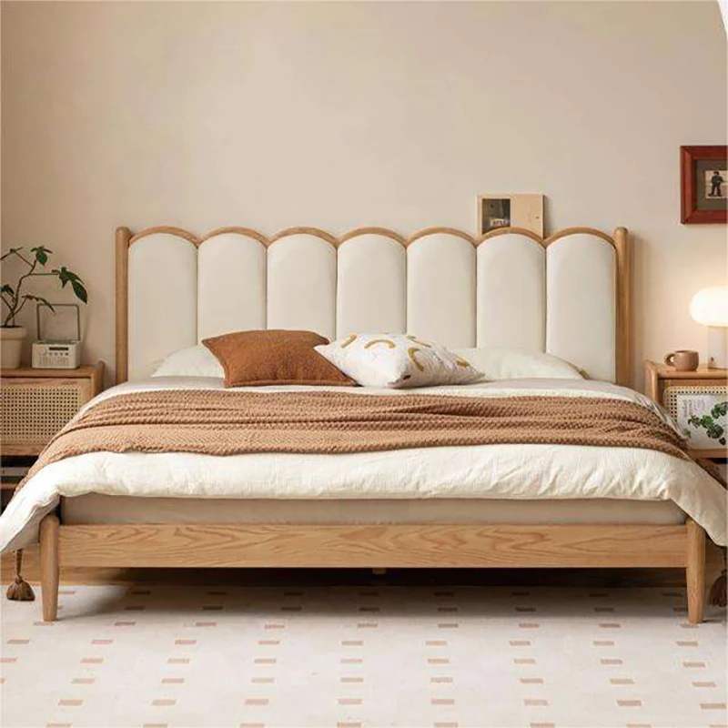 Oak bed with cream scalloped upholstered headboard in a bedroom scene