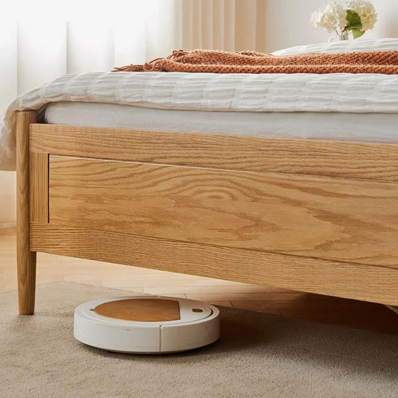 oak-bed-frame-robot-vacuum-clearance-detail Robot vacuum cleaning under the oak bed frame showing generous ground clearance