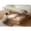 Oak gas lift bed with underbed storage compartments opened to show capacity