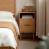 oak-nightstand-open-shelf-bedroom-lifestyle-scene Oak nightstand with open shelf beside a bed in a warm lifestyle bedroom scene