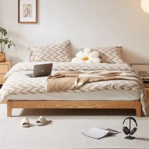 oak-platform-bed-frame-bedroom-lifestyle-scene Low platform bed in oak with grey tufted backrest styled in a bedroom scene