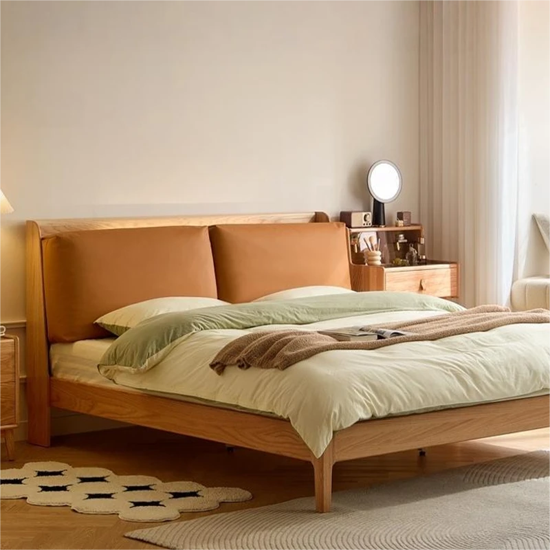 Oak platform bed with tan leather cushion headboard in a bright bedroom corner