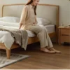 Oak bed with cream upholstered headboard in a cozy lifestyle bedroom scene