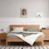 Solid oak platform bed shown from the front in a bright bedroom setting