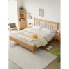 Cherry wood platform bed with spindle headboard in a bright japandi bedroom scene