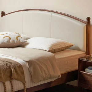 Black walnut bed frame with arched upholstered headboard in a warm bedroom scene