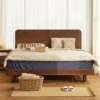 walnut-bed-headboard-and-nightstand-closeup Walnut low platform bed frame with wide headboard styled with a matching nightstand in a bright bedroom