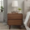 Walnut nightstand with drawers open in a styled bedroom bedside scene