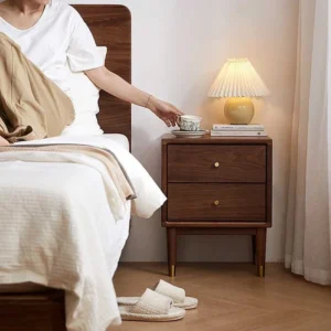 Walnut nightstand with two drawers beside a lamp in a warm bedside scene