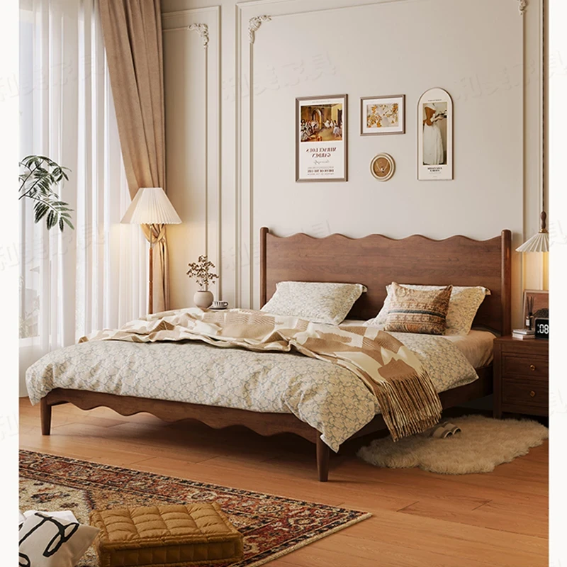 Walnut platform bed frame with wavy headboard in a warm lifestyle bedroom scene